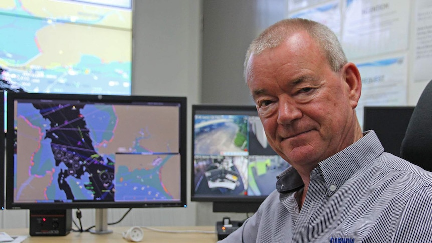 Ian Niblock sits in the port's harbour control room with several monitors behind him.