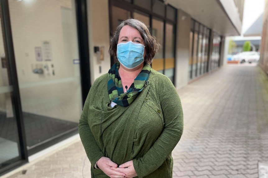 woman with green shirt in blue mask