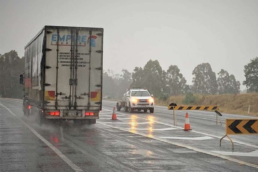 Traffic diversion on wet highway.