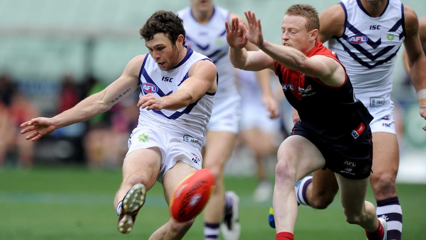 Fremantle's Hayden Ballantyne kicks a goal past Melbourne's Sam Blease at the MCG.