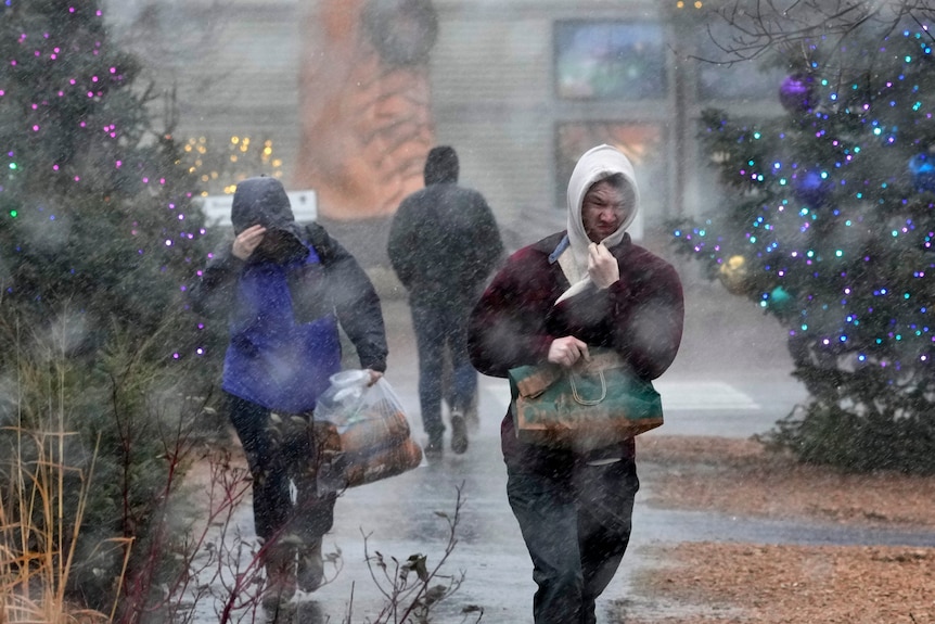 Two people covering their faces in the rain 