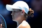 A female Australian tennis player checks the strings on her racquet at the Australian Open.