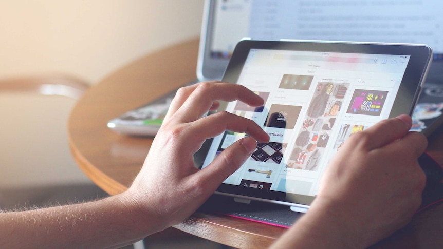 A person uses an ipad to shop on ebay while also checking their emails.