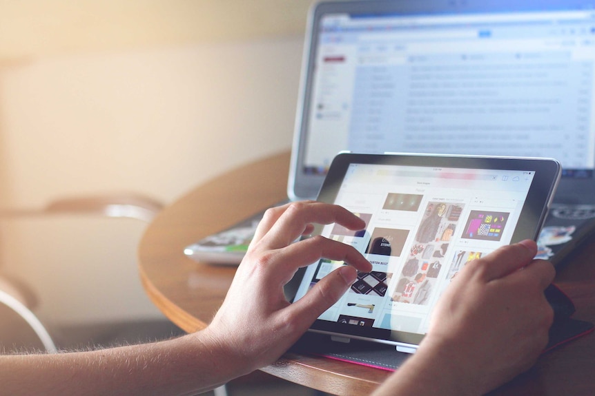A person uses an ipad to shop on ebay while also checking their emails.