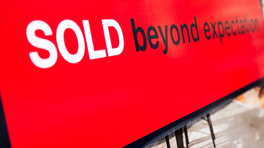 A real estate sign reads 'sold beyond expectation'