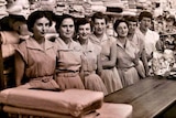 A black and white image showing women inside a material store in the 1950s.