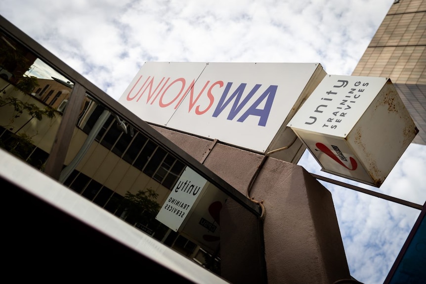 A picture of a Unions WA sign outside a building with an overcast sky int he background.