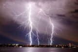 Lightning strikes over the Swan River as a thunderstorm hits Perth.