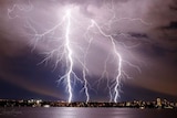Lightning strikes over the Swan River as a thunderstorm hits Perth.