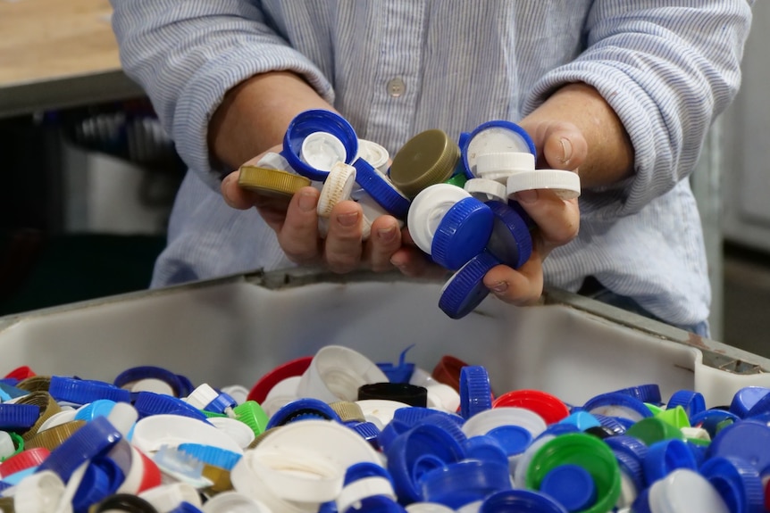 Close of hand holding plastic bottle tops
