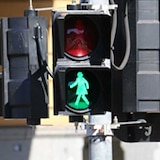 A pedestrian crossing light flashes with a female silhouette.