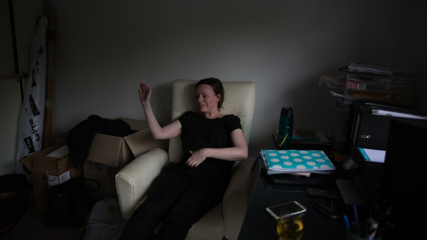 Anita Harding slumps into a chair, exhausted, at home.