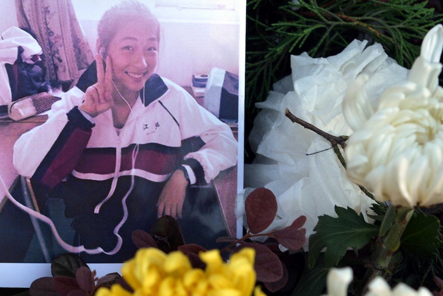 Photo of Wang Linjia placed among flowers outside her high school in China.