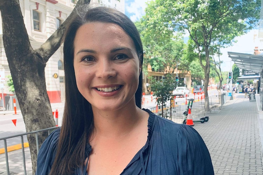 Smiling photo of RACQ spokeswoman Lauren Ritchie standing in Adelaide Street in Brisbane CBD.
