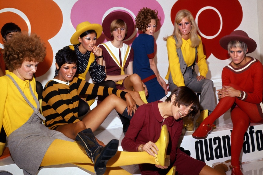 A group of models wearing bright yellow and red designer clothing