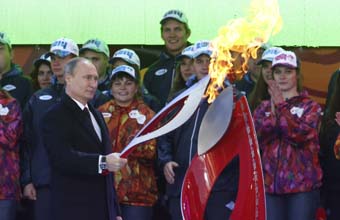 Russian president Vladimir Putin holds a lighted Olympic torch