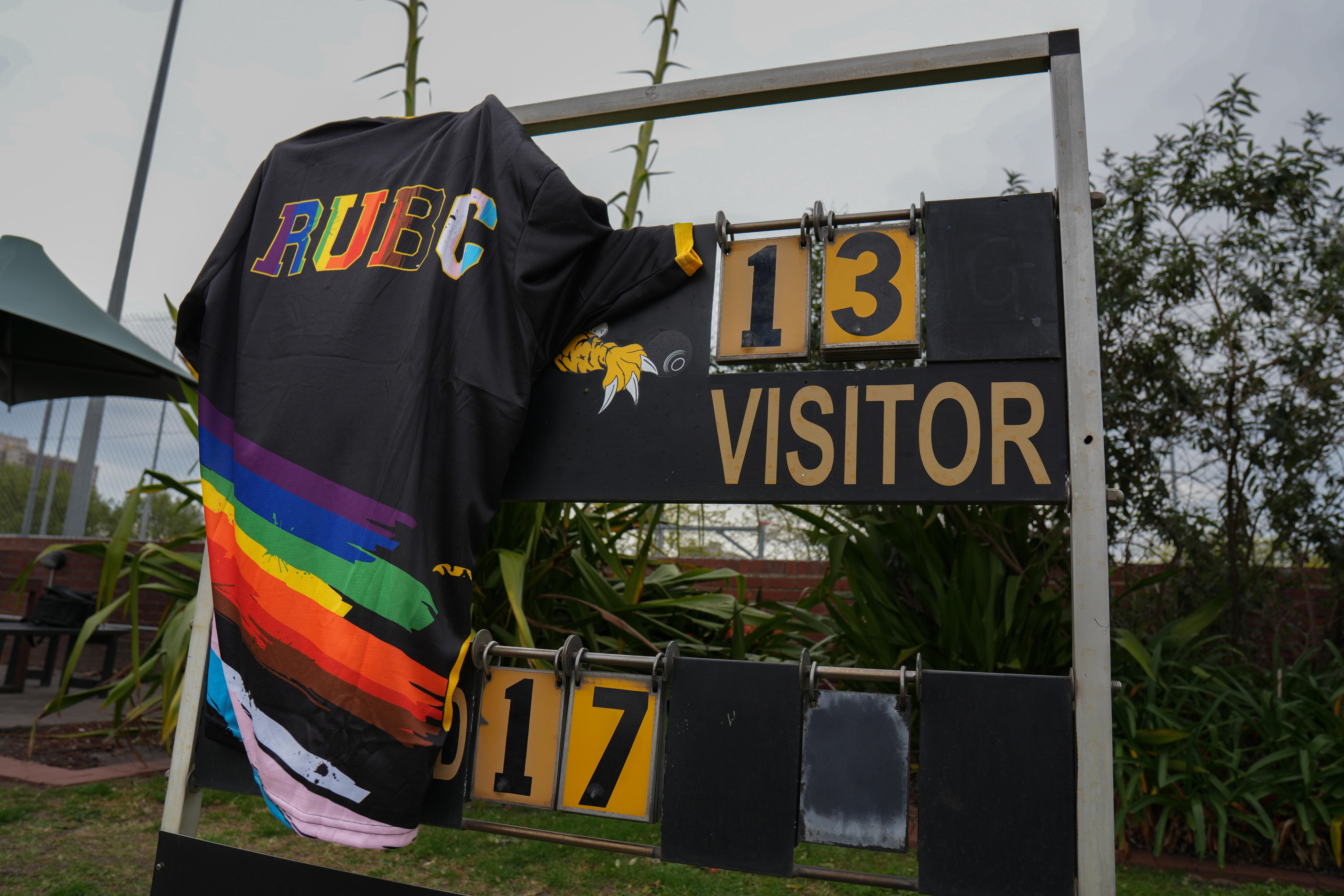 Uma camisa polo multicolorida está pendurada sobre um placar de boliche.