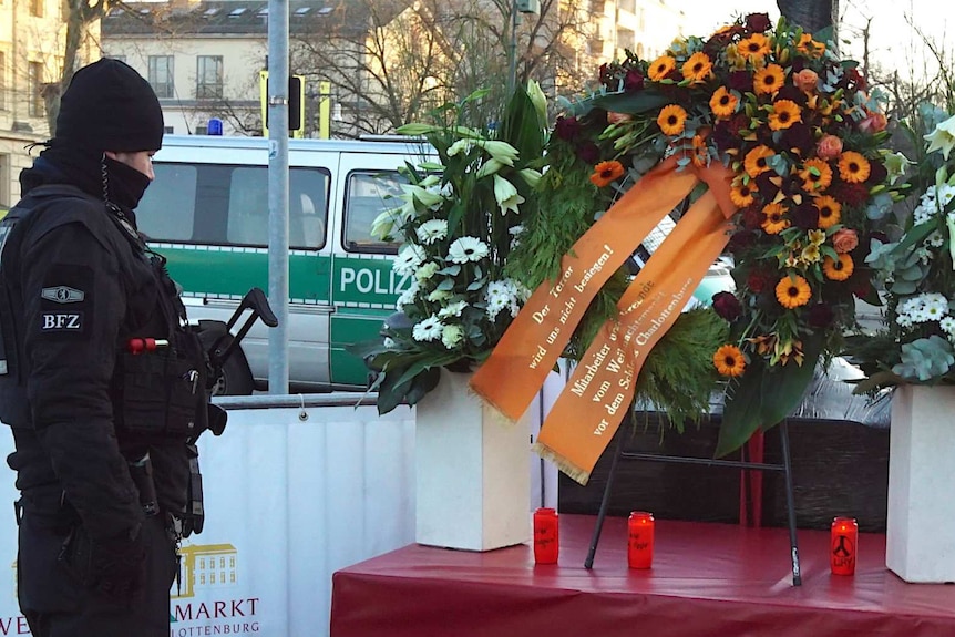 Policeman looks at Berlin truck attack tribute.