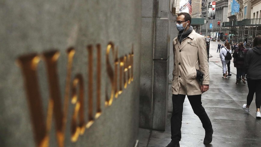 A man wears a protective mask as he walks on Wall Street during the coronavirus outbreak in New York City.