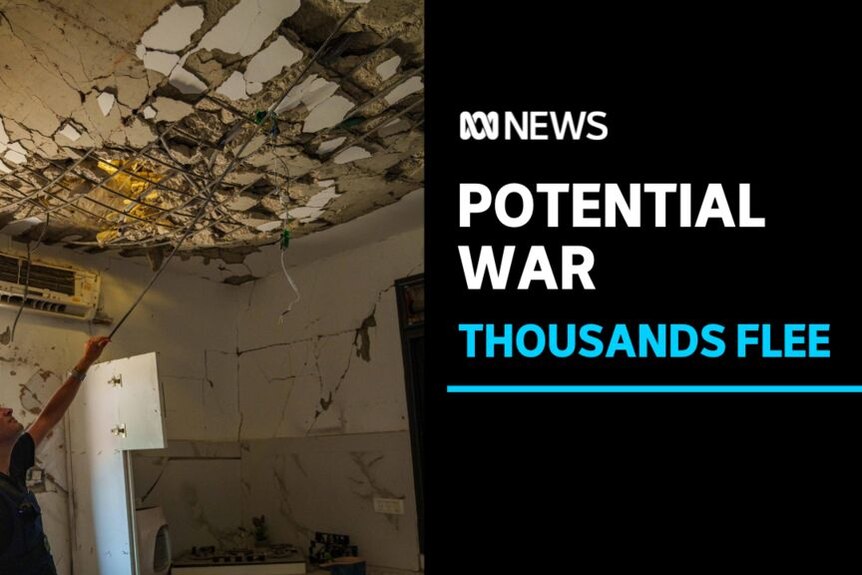 Potential War, Thousands Flee: A man indicates at a damaged ceiling inside a home.