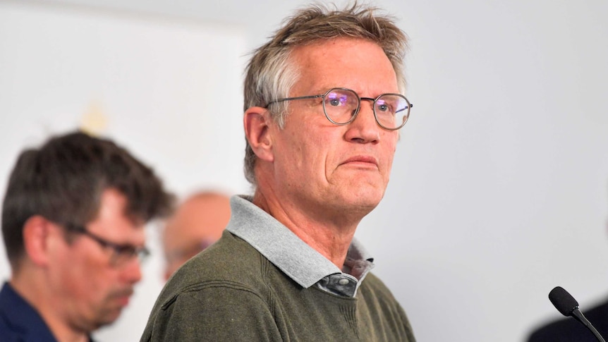 Anders Tegnell, wearing a grey collared shirt and dark-rimmed glasses, frowns slightly