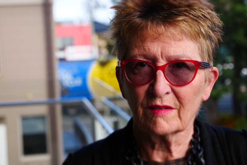 woman with glasses looking at camera