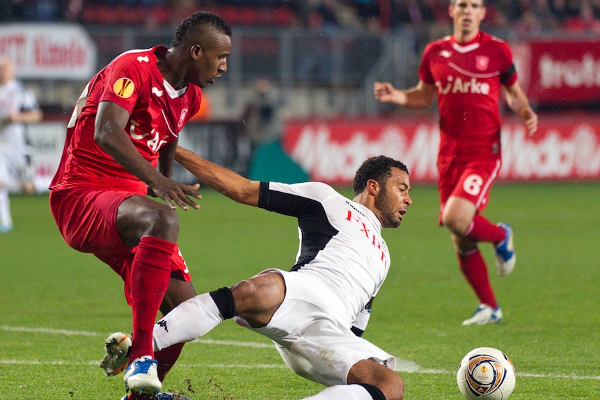 Twente's Douglas (L) fights for the ball with Fulham's Moussa Dembele.