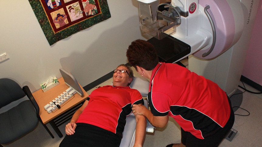 One woman lying in a mammography chair at a BreastScreen Queensland
