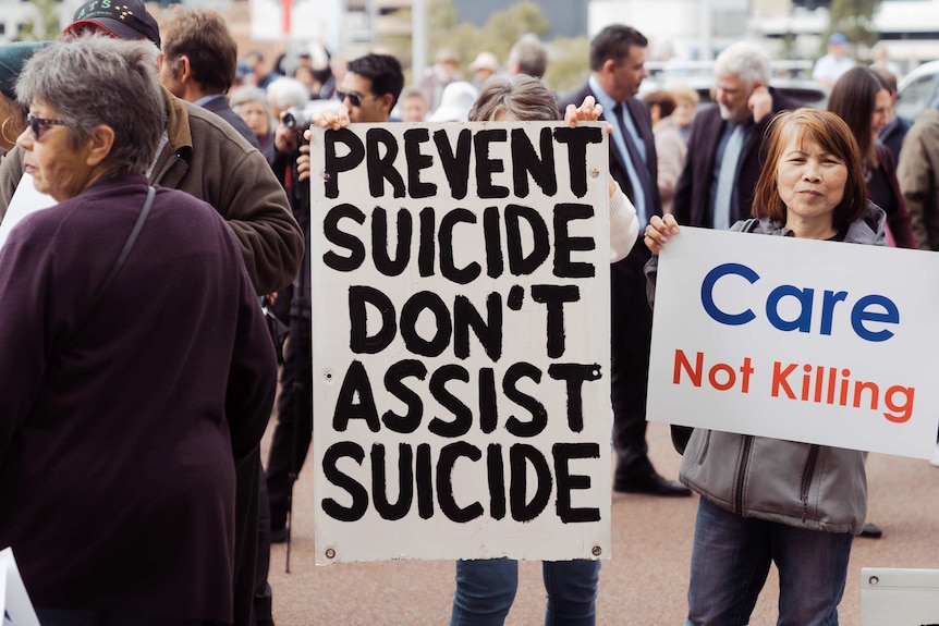 Anti euthanasia protesters hold signs at a rally outside WA Parliament.