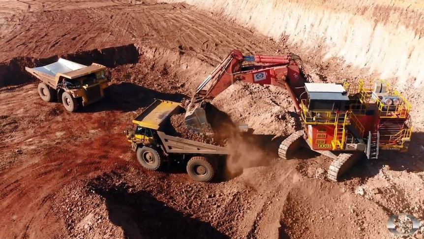 Trucks dig at a manganese mine