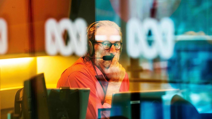 Jon Faine glances out of the radio studio window during a broadcast of his Mornings program