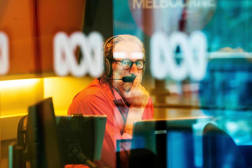 Jon Faine glances out of the radio studio window during a broadcast of his Mornings program