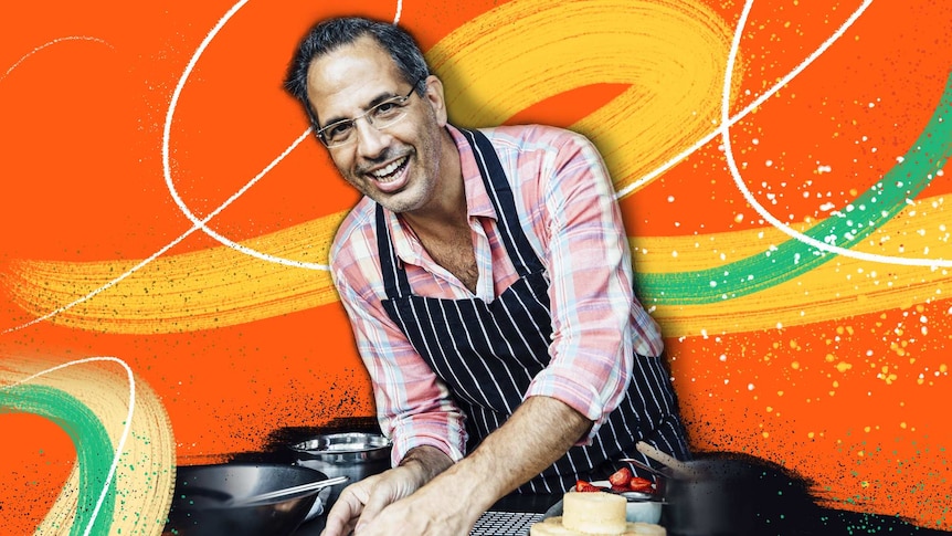 Yotam Ottolenghi smiles and cooks in a kitchen setting for an article about Yotam's career tips.