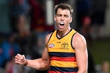 Adelaide Crows player Riley Thilthorpe clenches his fist and shouts after an AFL goal against St Kilda.