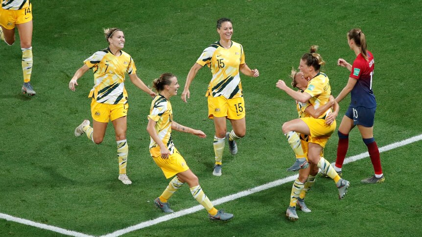 Elise Kellond-Knight and her Matildas teammates celebrate scoring a goal