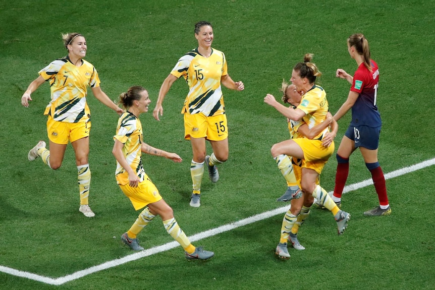Elise Kellond-Knight and her Matildas teammates celebrate scoring a goal