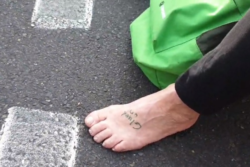A protester's foot glued to the road in Adelaide's CBD.