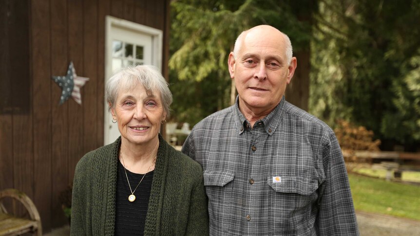 Larry and Rosemary Brester smile as they stand outside their home.
