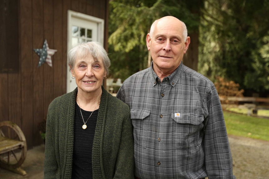 Larry and Rosemary Brester smile as they stand outside their home.
