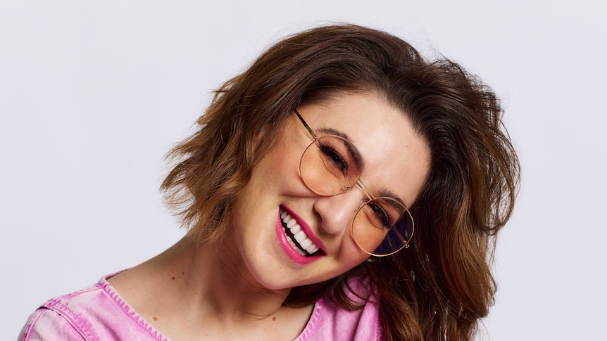 Women wearing bright pink and glasses smiling 