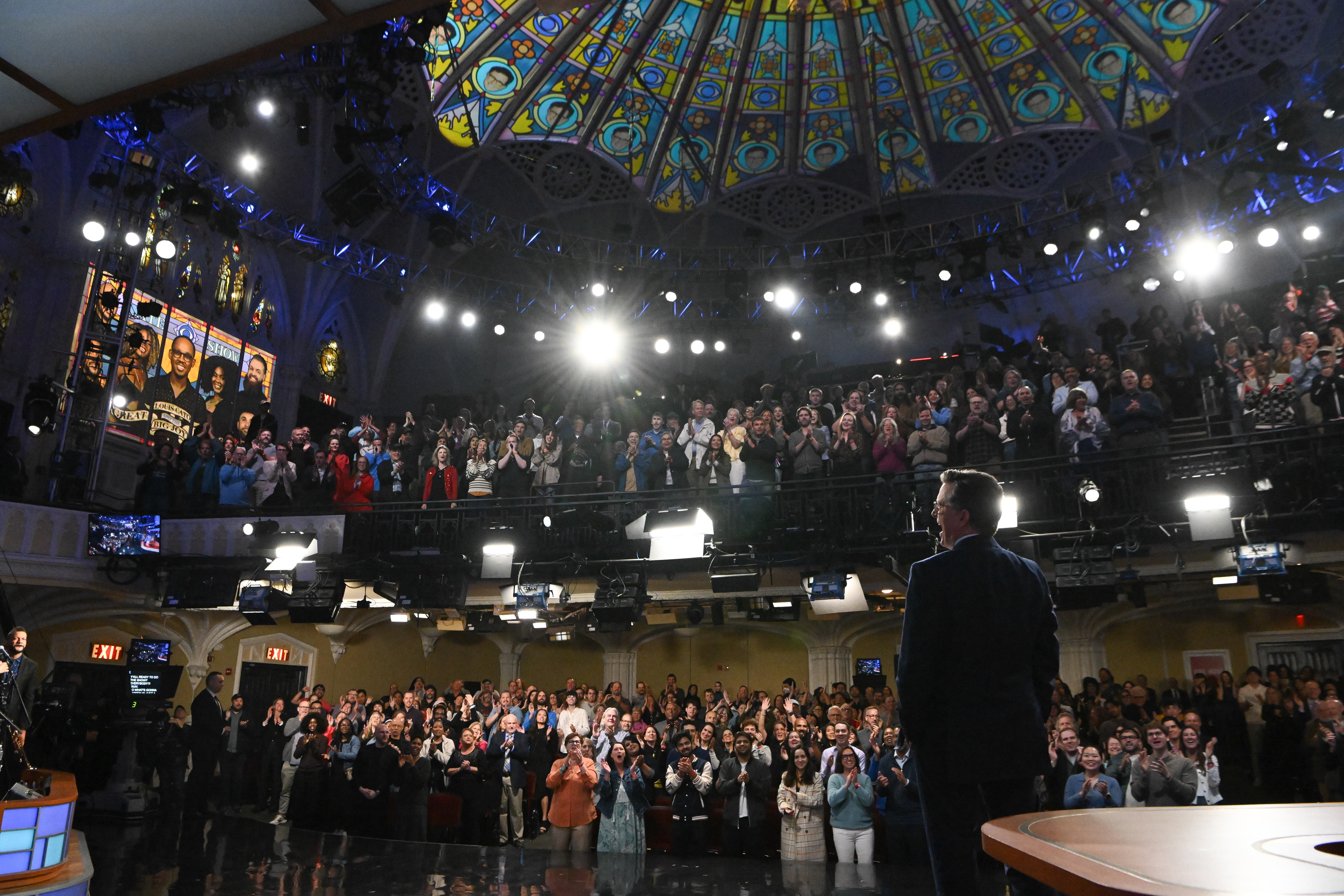Stephen Colbert faces the audience as they give him a standing ovation in the Ed Sullivan Theater.
