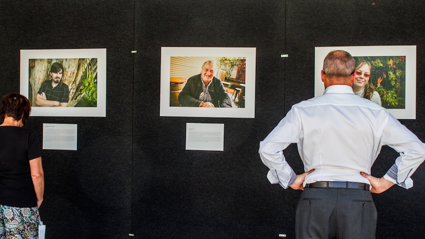 City workers stop to read the stories of people affected by mental health as part of the photography exhibition.