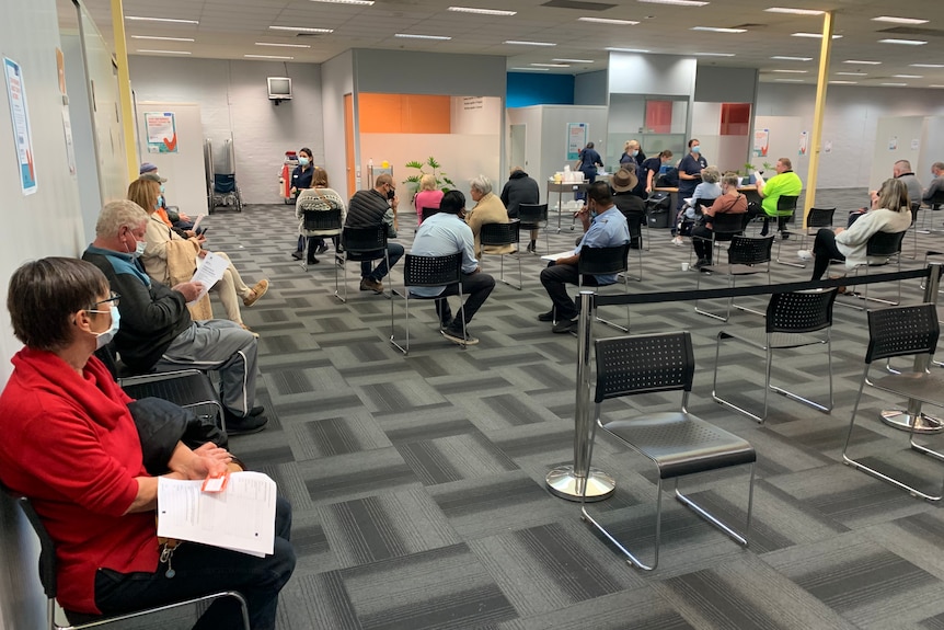 People sitting on chairs inside the Bendigo vaccination centre.