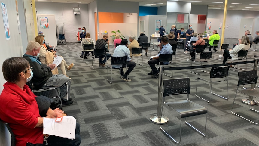 People sitting on chairs inside the Bendigo vaccination centre.