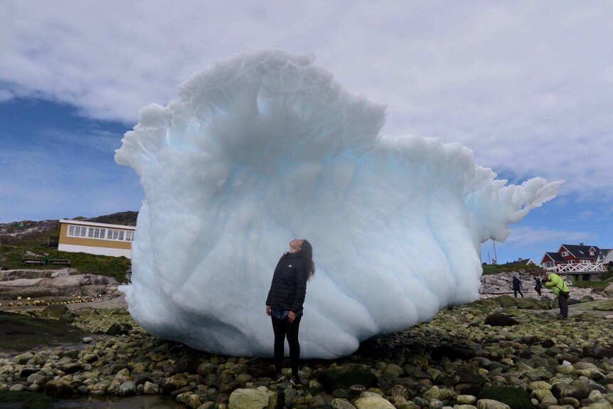 Kalinda Palmer and a large piece of ice in Greenland