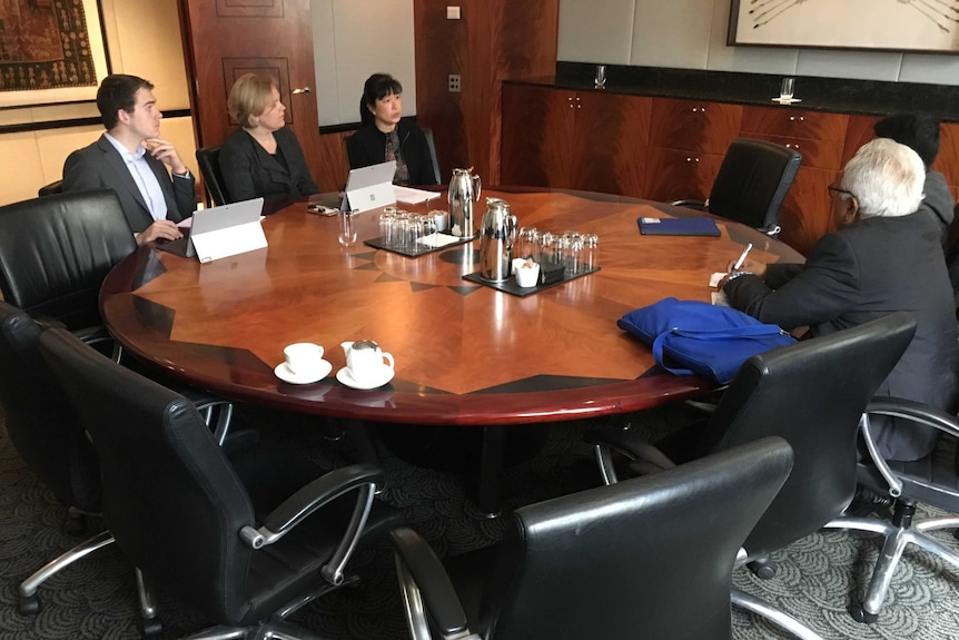 Leanne Ho (right) and colleagues chat with an asylum seeker and his interpreter.