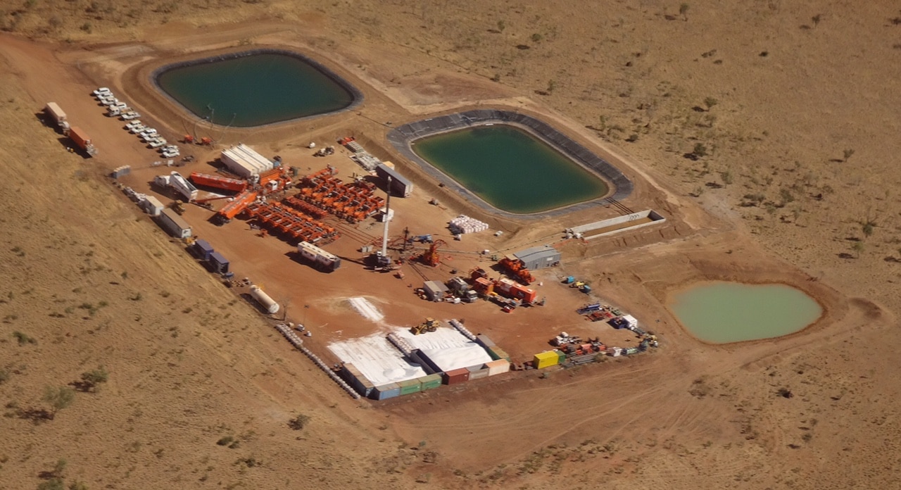 Aerial view of a gas well operation, including two water ponds