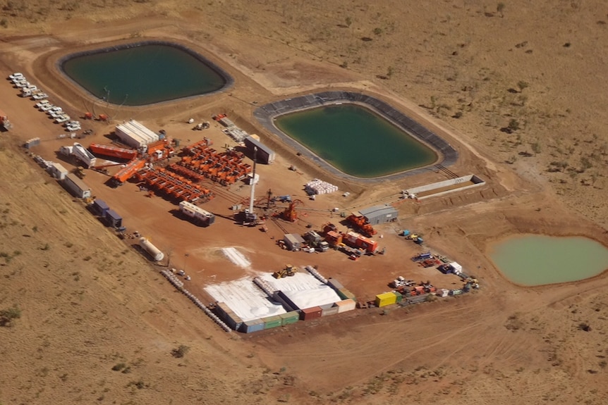 Aerial view of a gas well operation, including two water ponds
