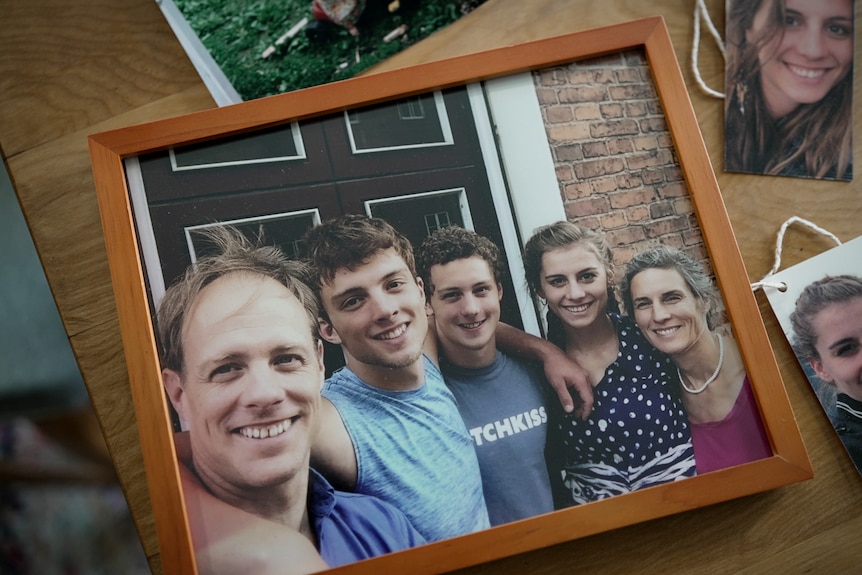 A portrait showing a smiling family including two parents, two boys and a girl.