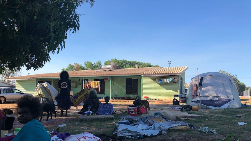 Four residents, a dog, two tents and a green house are pictured